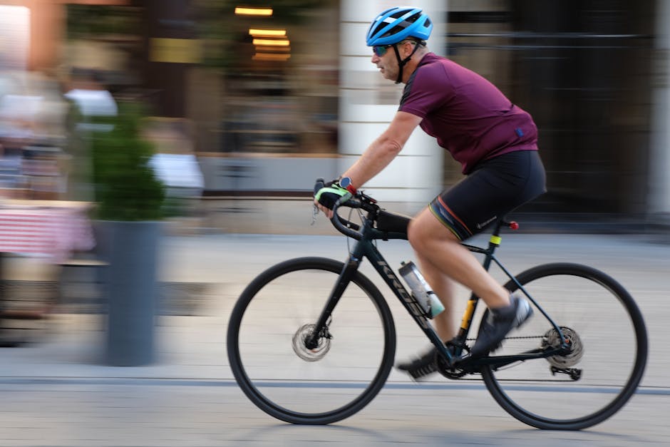 Ciclista che pedala in strada cittadina, rappresentazione della mobilità sostenibile urbana