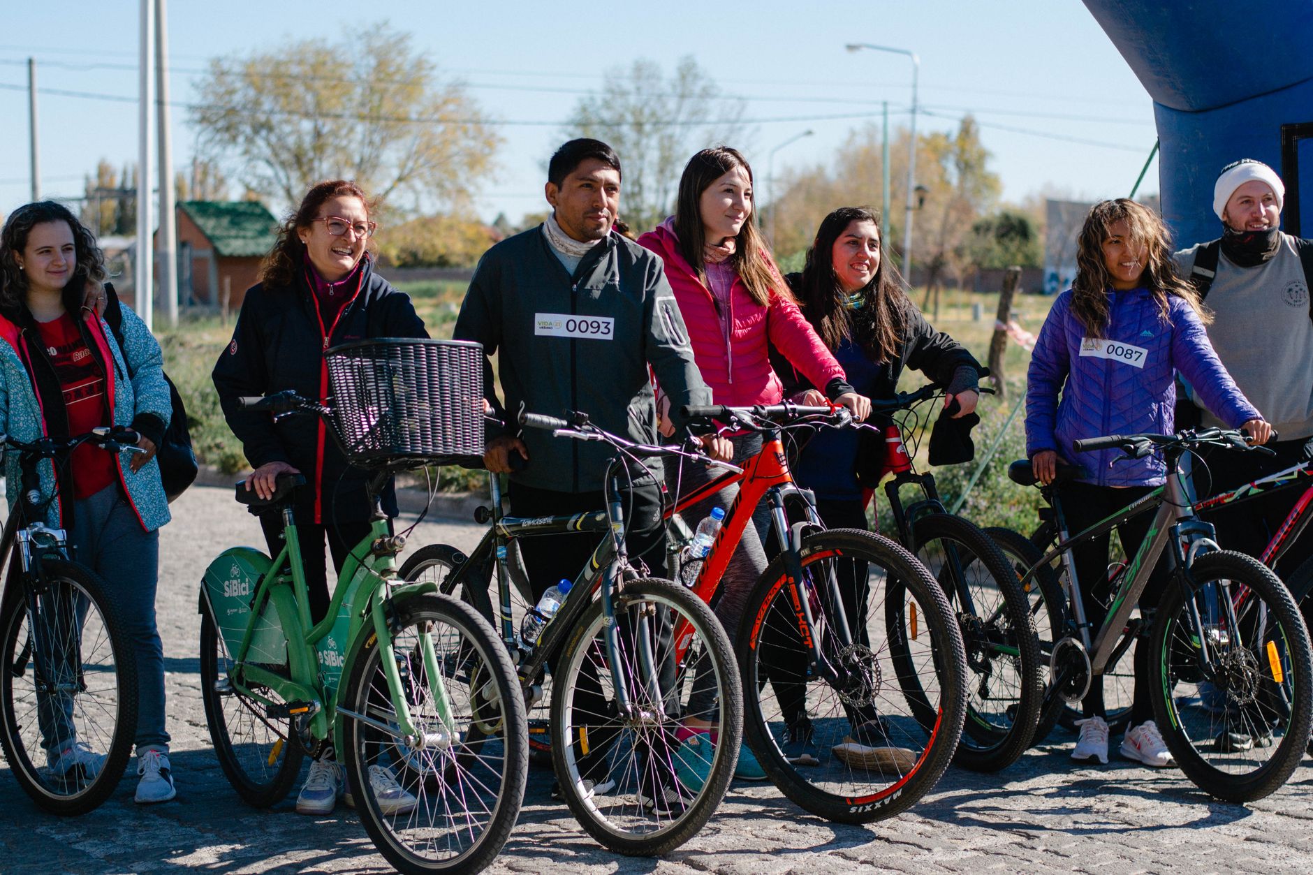 Un gruppo eterogeneo di persone con biciclette che gode di una giornata di sole all'aperto