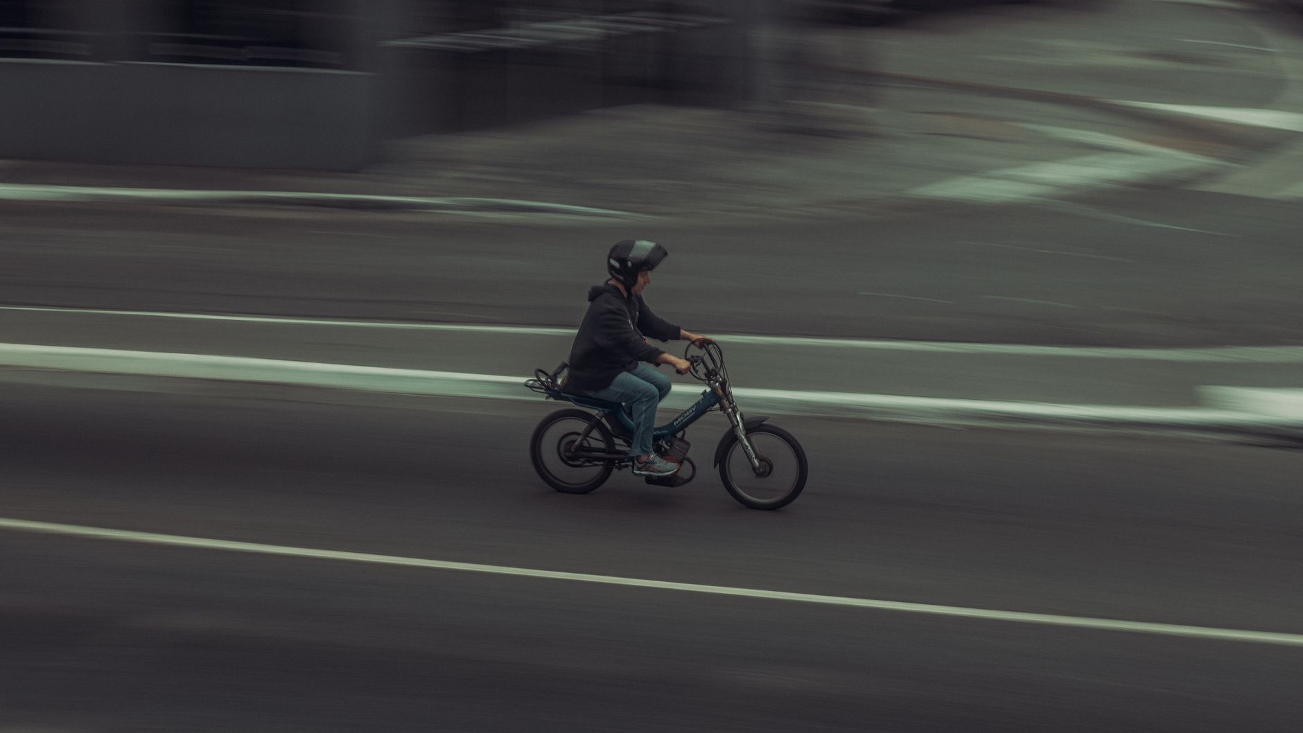 Ciclista in movimento sfocato su strada urbana, cattura la velocità e il flusso del traffico ciclistico in città