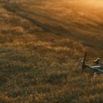 Una bicicletta solitaria in un campo dorato al tramonto, simbolo di direzione futura e rete ciclabile che si estende all'orizzonte