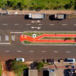 Veduta aerea di una strada urbana con pista ciclabile segnalata, intersezioni e flusso traffico